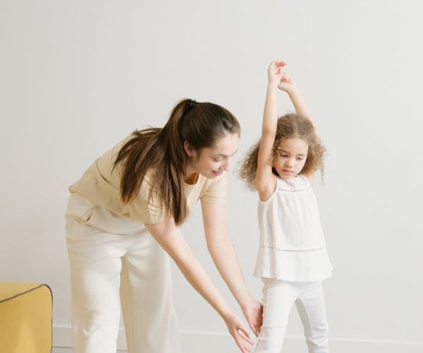 Woman smiling and stretching in a bright room.